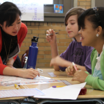 Teacher and 2 students working together at a table