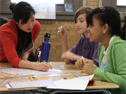 Teacher and 2 students working together at a table